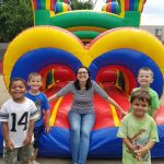 Miss Amanda and four boys at a bouncy castle.